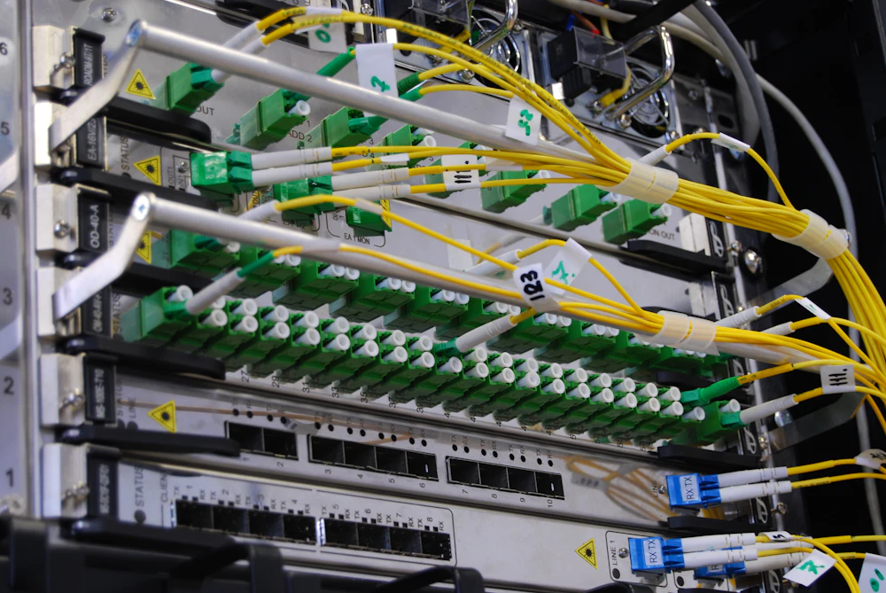 Gelbe Single-Mode-Glasfaserkabel, gesteckt in ein Patchfeld in einem Netzwerkschrank